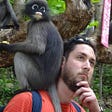 Photo of writer Russell Jones, with a monkey on his shoulder, in Thailand