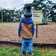 A pre-school child observing the ‘Area Closed’ sign at the park