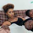 A group of Black women laying together on a couch
