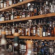 A bar whose shelves are filled with bourbon.