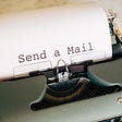 Typewriter with a paper with words typed: Send a Mail
