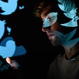 In this photo illustration, the logo for the Twitter social media network is projected onto a man’s face.