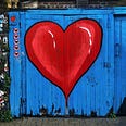 Photo provided by Unsplash. Many thanks to them. Picture is of a blue painted door with a red heart in the middle.