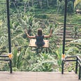 girl on swing overlooking rice paddy fields in Bali