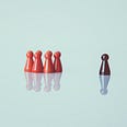 One playing figure standing out in a different color, separated from a group huddled close together.