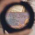 This is a picture of a magnifying glass over the American Constitution.