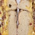 A close-up of the cut side of a bacon, egg, and cheese sandwich on a bagel.