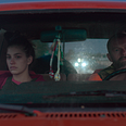 Camila Morrone (left) and James Badge Dale (right), seen tense and stone-faced through a car windshield in the film.