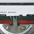 A typewriter with the words ”Stories matter” typed on a white paper.
