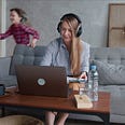 Woman works from home as kids play in the background