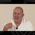 Jony Ive speaking on a video call in a white hoodie. He is smiling and contemplating before speaking.
