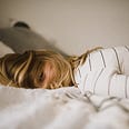 woman laying down feeling sick keto flu
