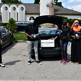 A group of volunteers around a car