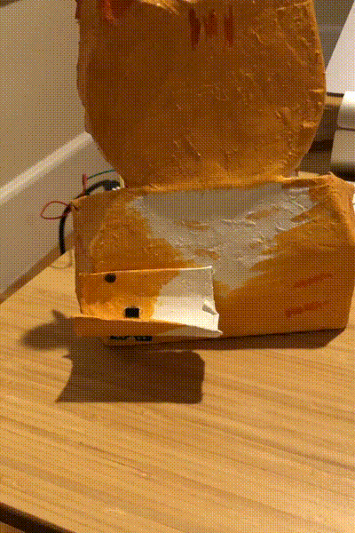 A gif of a roll of litter bags being placed on a crafted cat’s paw