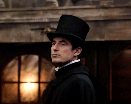 Claes Bang smirks at the camera as a top-hat wearing Count Dracula