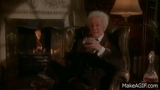 Man sitting by fire with glass of brandy