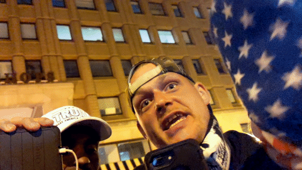 A gif of a man in a backward baseball cap screaming while another man jabs his finger at the camera aggressively