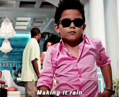 Animated photo of a young boy in a dress shirt, sunglasses, and spiked hair tossing money into the air, representing sales