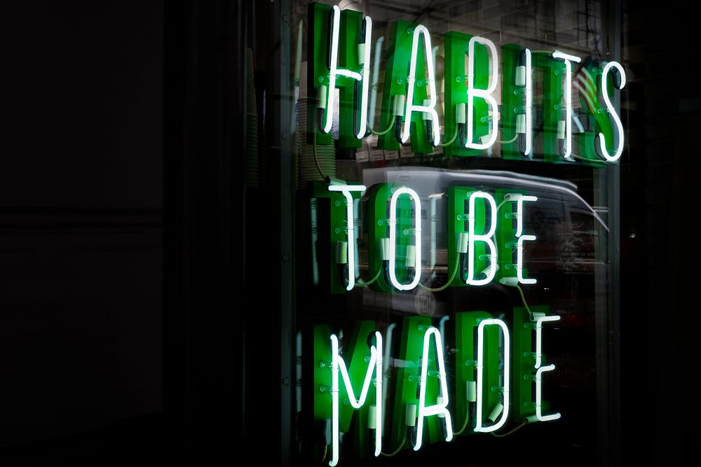The words “Habits to be made” in neon light sign.