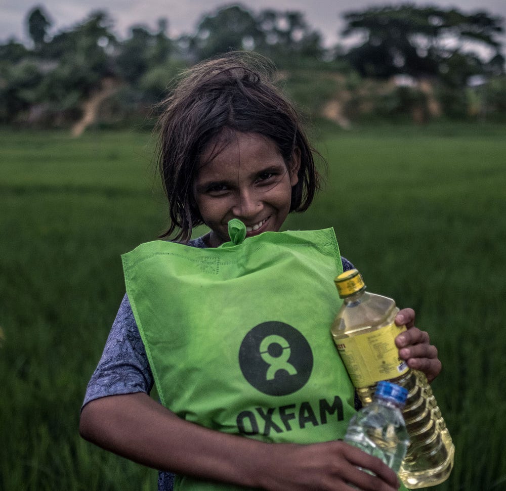 Shim*, 12, holds an Oxfam food parcel she received from a distribution at Kutupalong Camp, Bangladesh. Tommy Trenchard/Oxfam