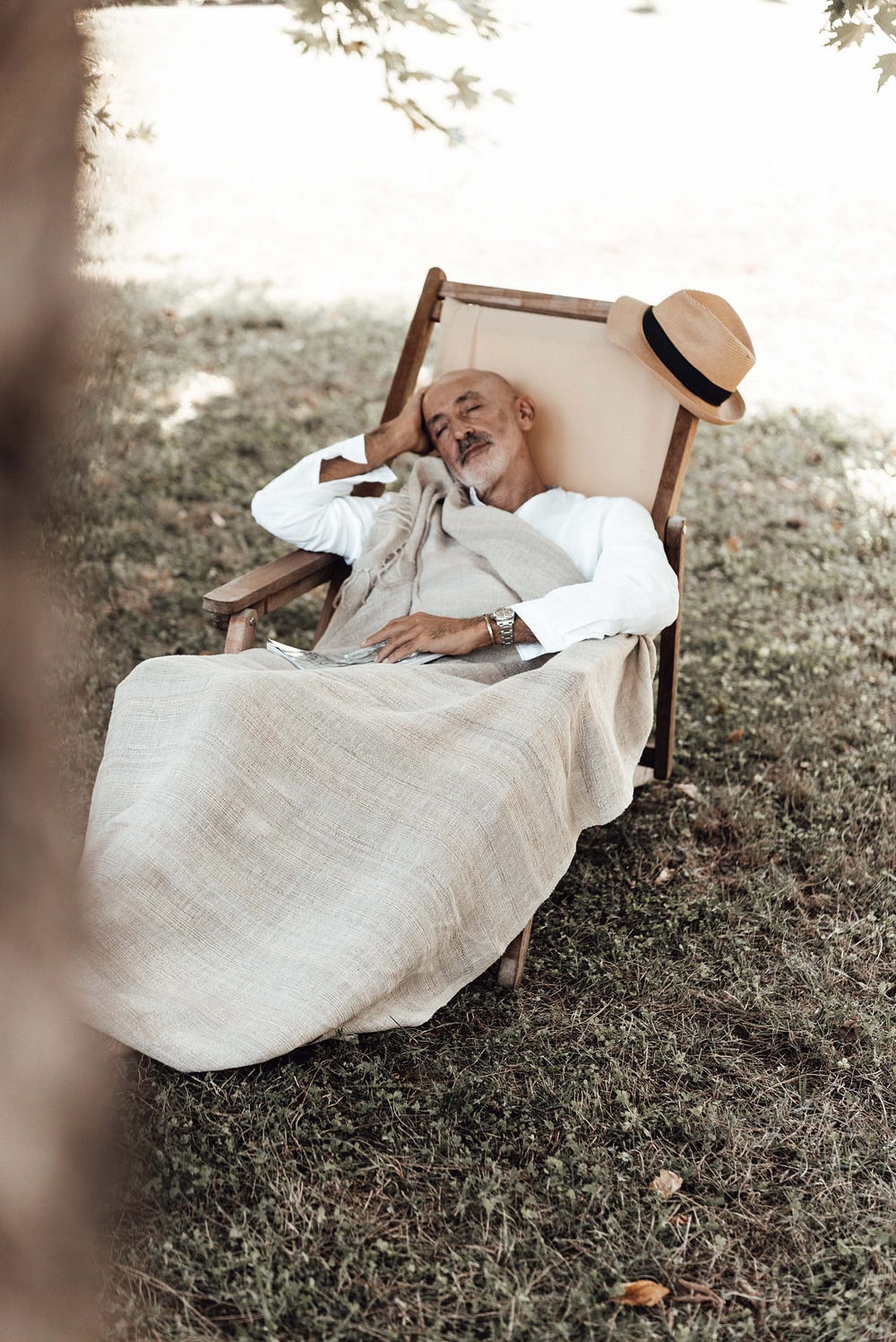 Older man asleep in lawn chair.