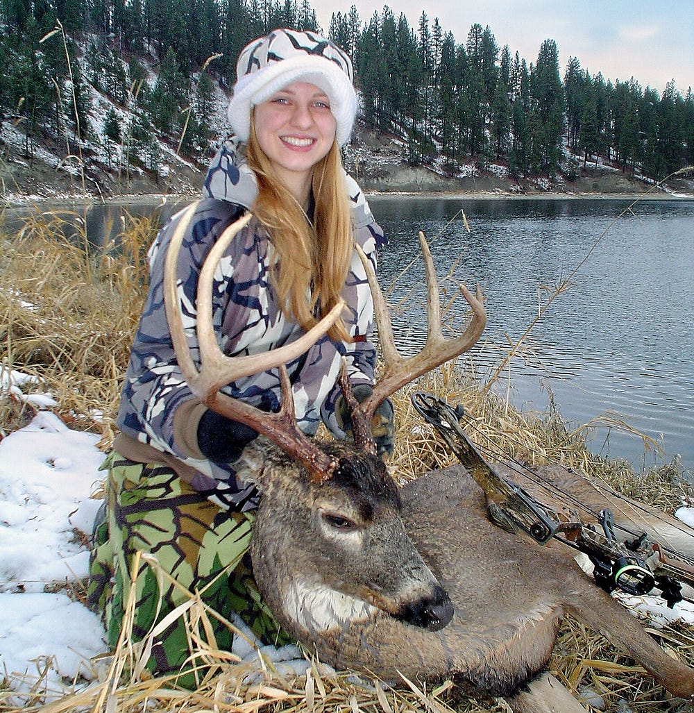 A girl displays the whitetail buck she harvested at Lake Roosevelt in Northeast Washington during a recent late archery season.