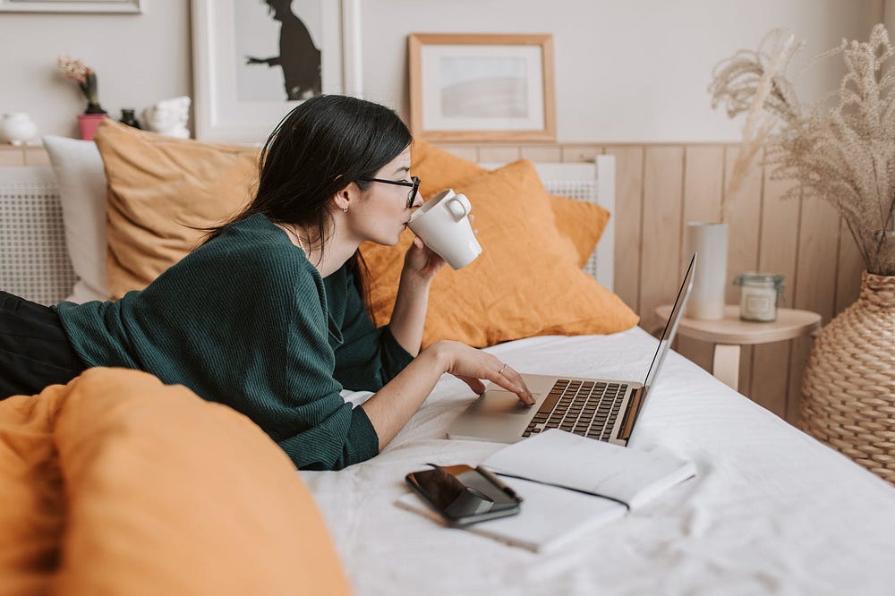 Woman sipping tea as she does a free online course to upgrade her content creation skills