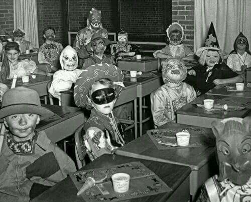 Schoolchildren dressed up for Halloween sitting at desks