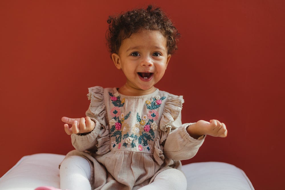 Adorable, curly-haired toddler with cute little teeth