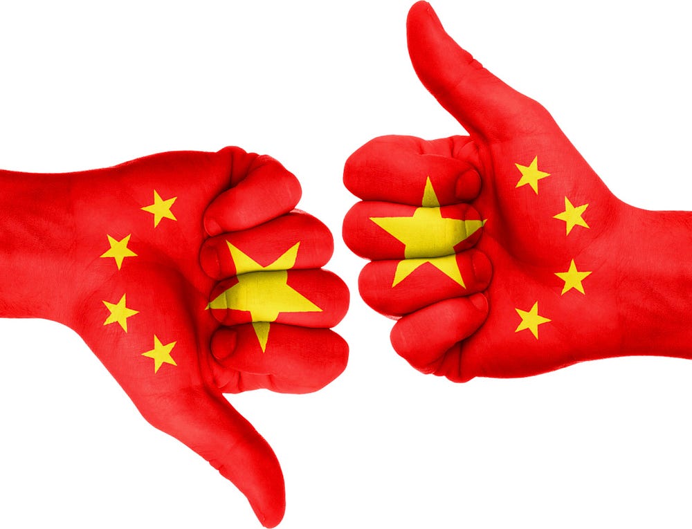 IMAGE: Two fists painted with the Chinese flag, one thumb up and the other thumb down