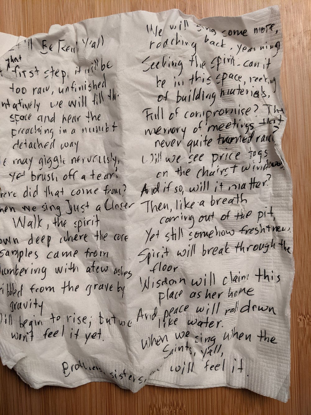 Crumpled napkin with something just barely legible in black finepoint marker.