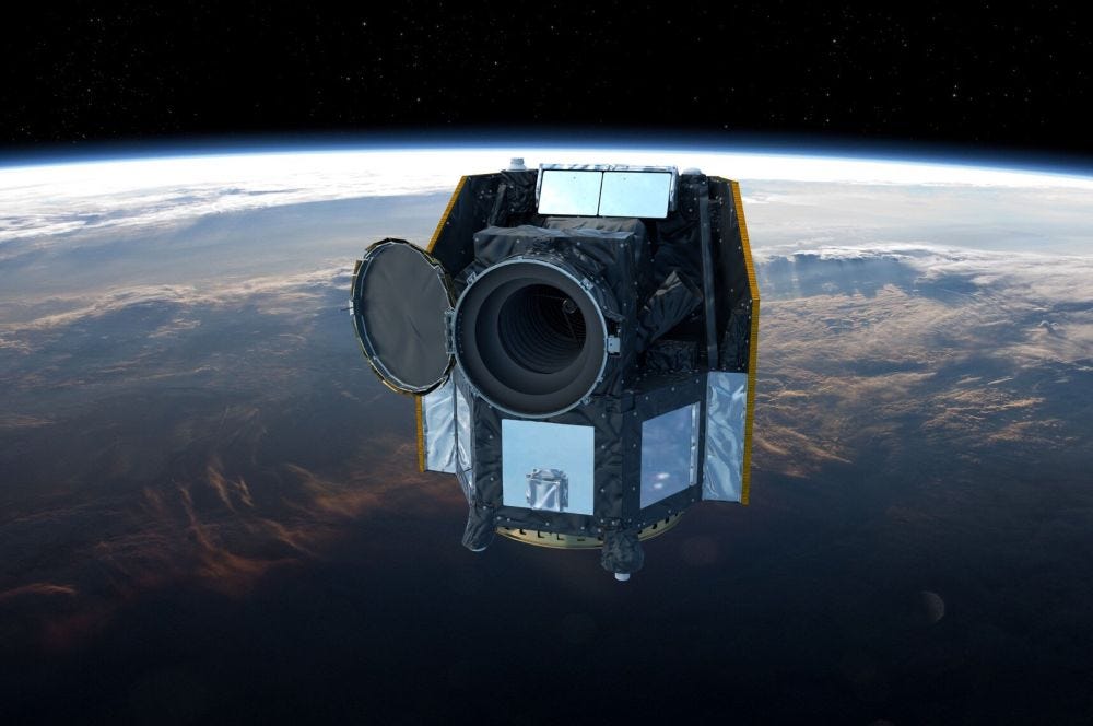 A dark, boxy-looking satelitte is pictured in orbit above Earth.