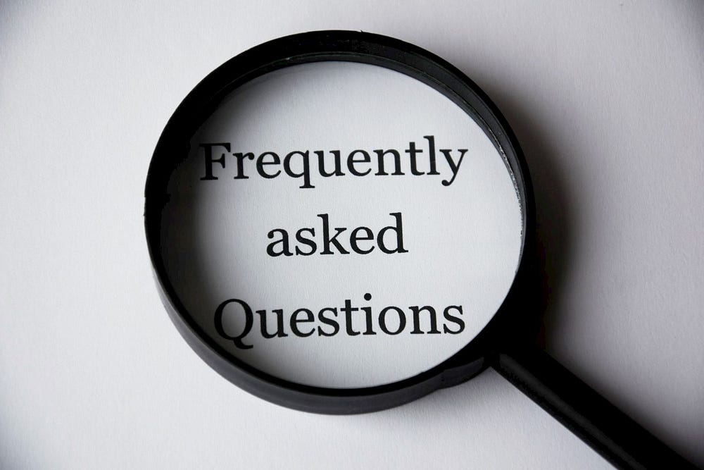 Black magnifying glass highlighting the phrase “Frequently asked Questions”