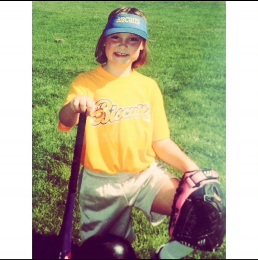 Mallory playing softball as a child.