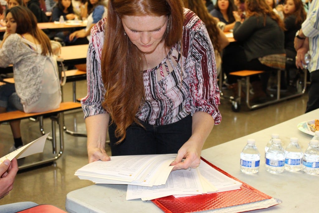 Development & Education Programs Coordinator Kristen Smith Eshaya prepares the program graduation certificates