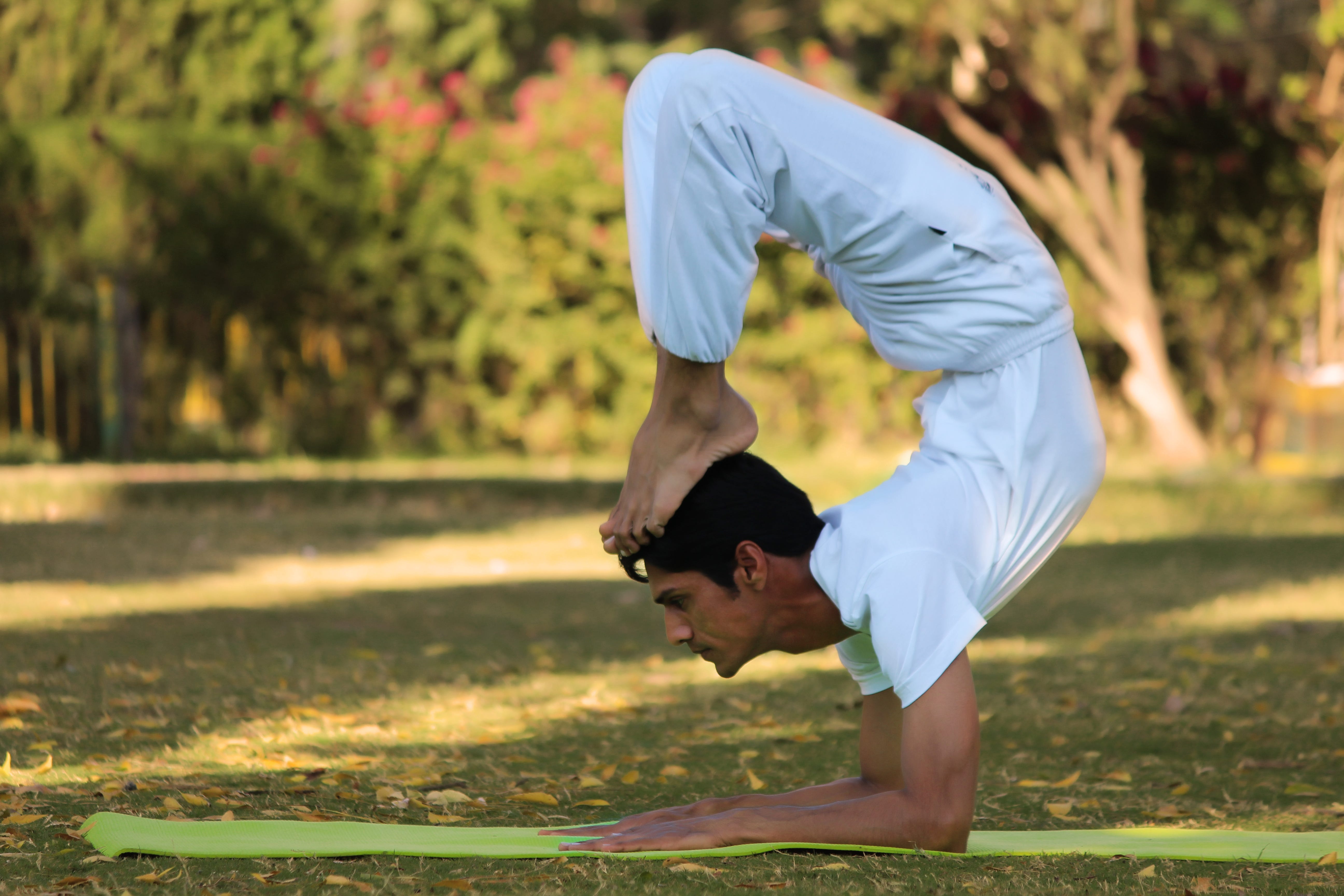 Indian good looking, strong man doing extreme yoga asana