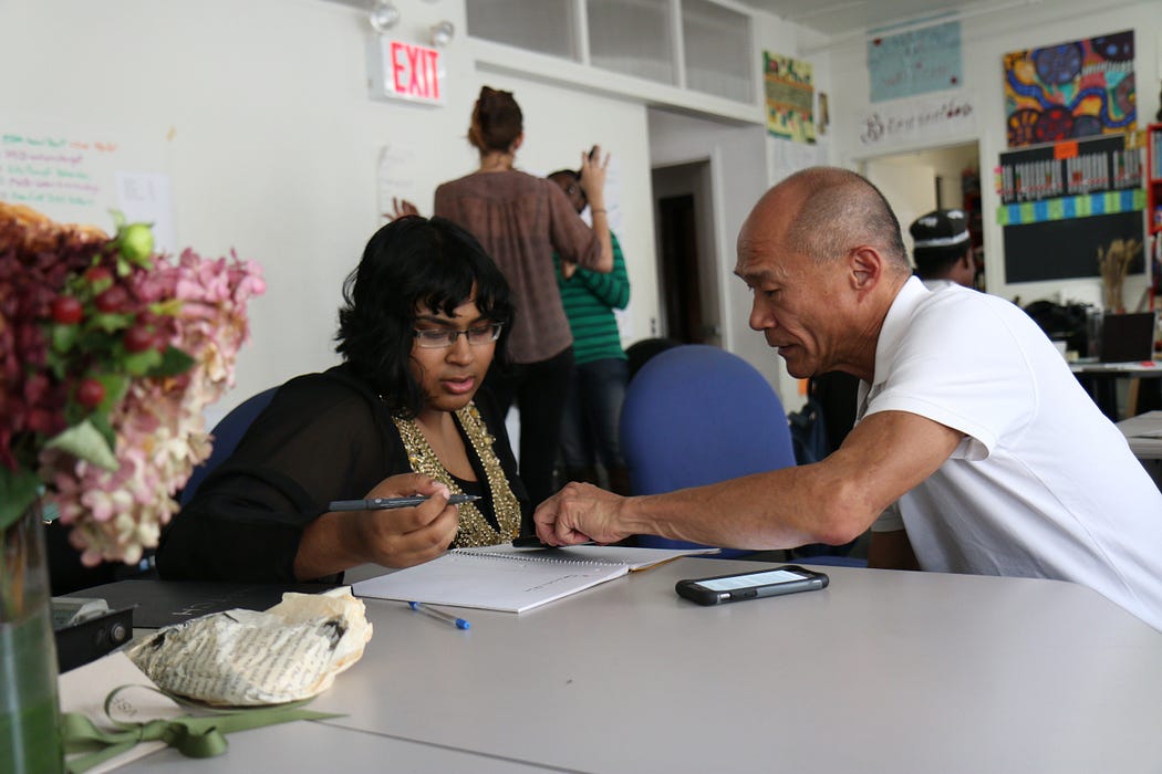 A woman teaching or talking to a man