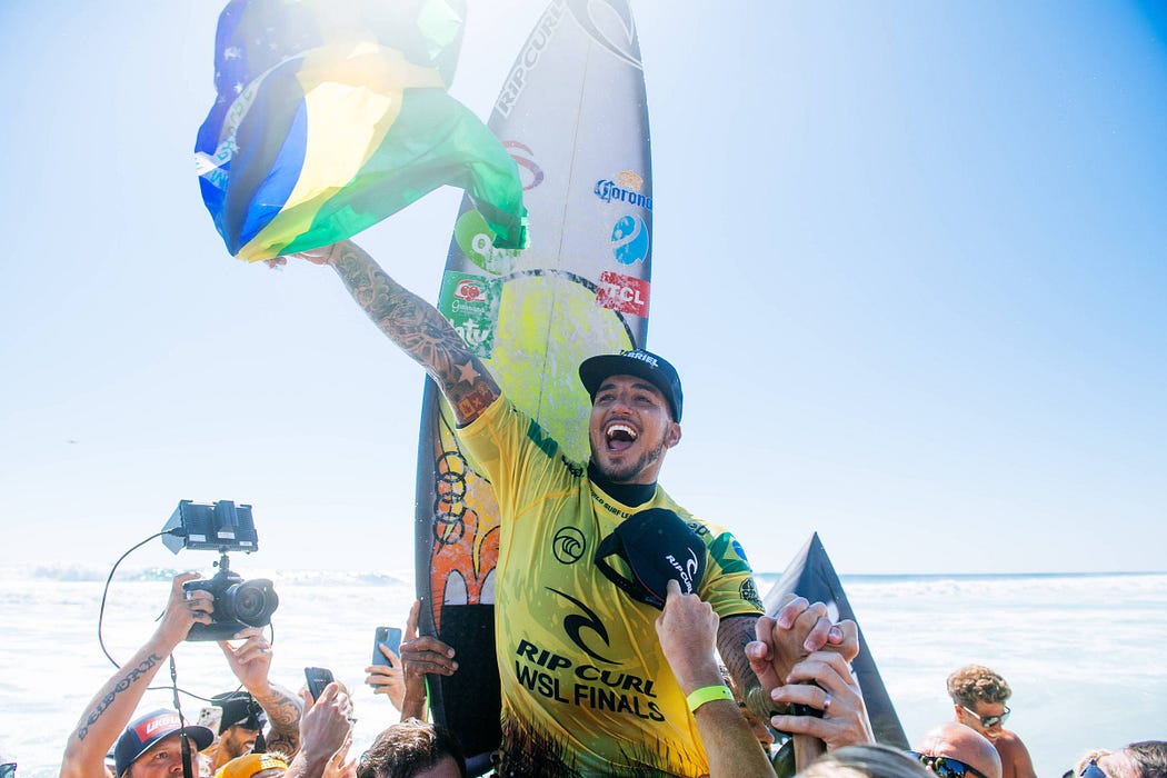 O paulista Gabriel Medina festejando com a bandeira do Brasil em mãos após conquista campeonato de surfe. 