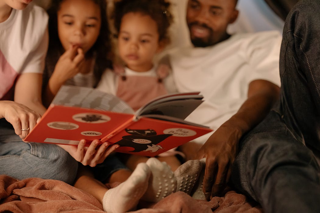 Two adults reading with two children