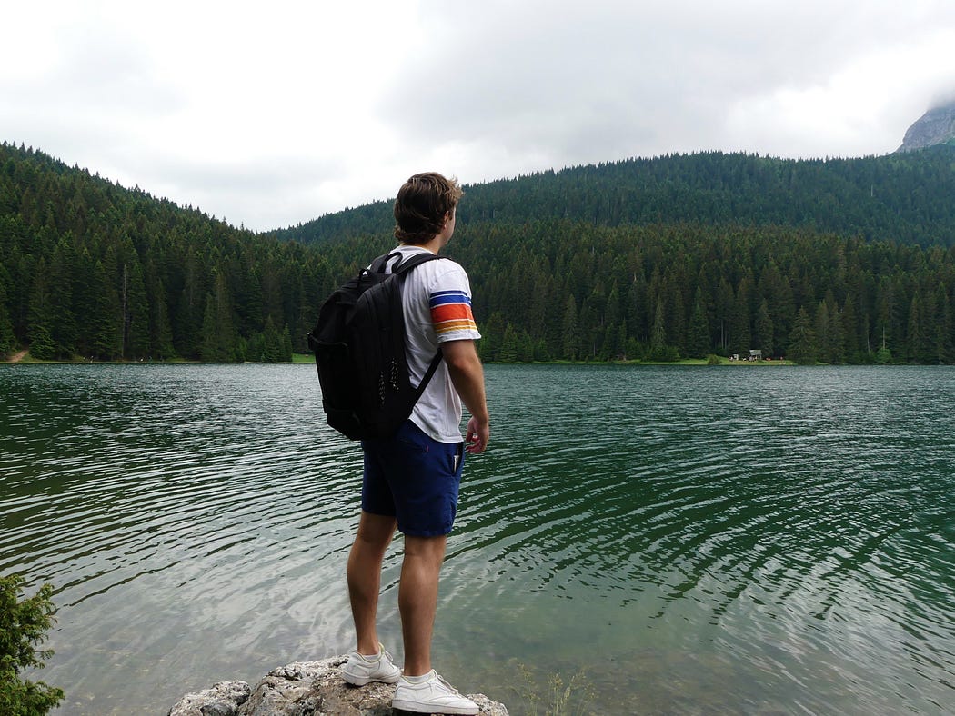 Tiani’s boyfriend Brett standing on a rock looking out onto the Black Lake in Montenegro