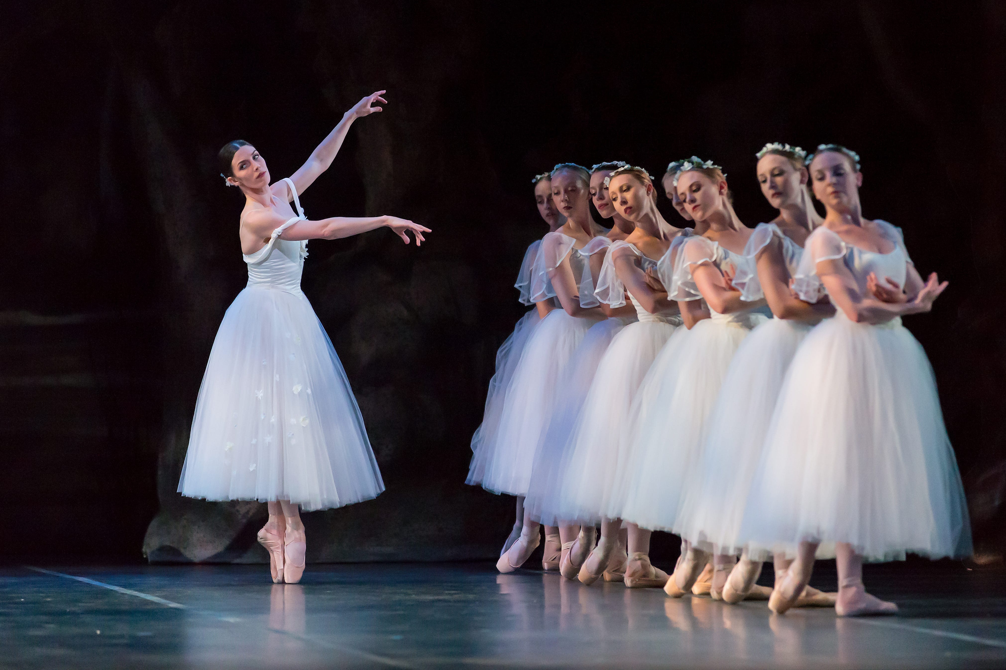a ballet performance with about 8 performers with an instructor on stage.