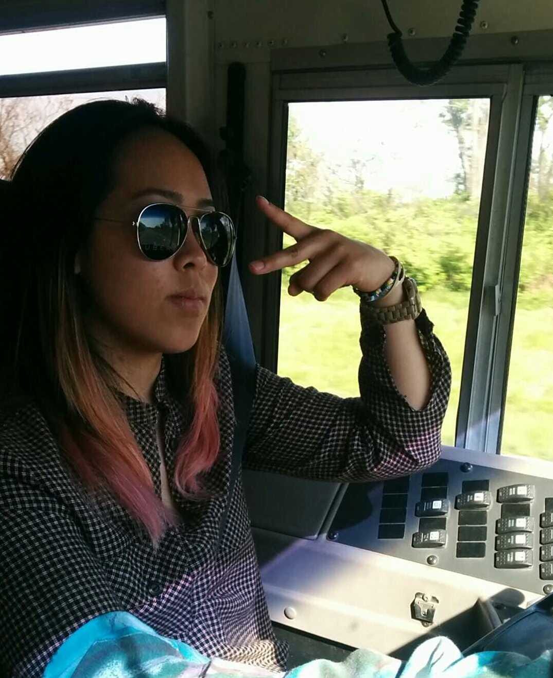 Losa throwing up the peace sign in the bus