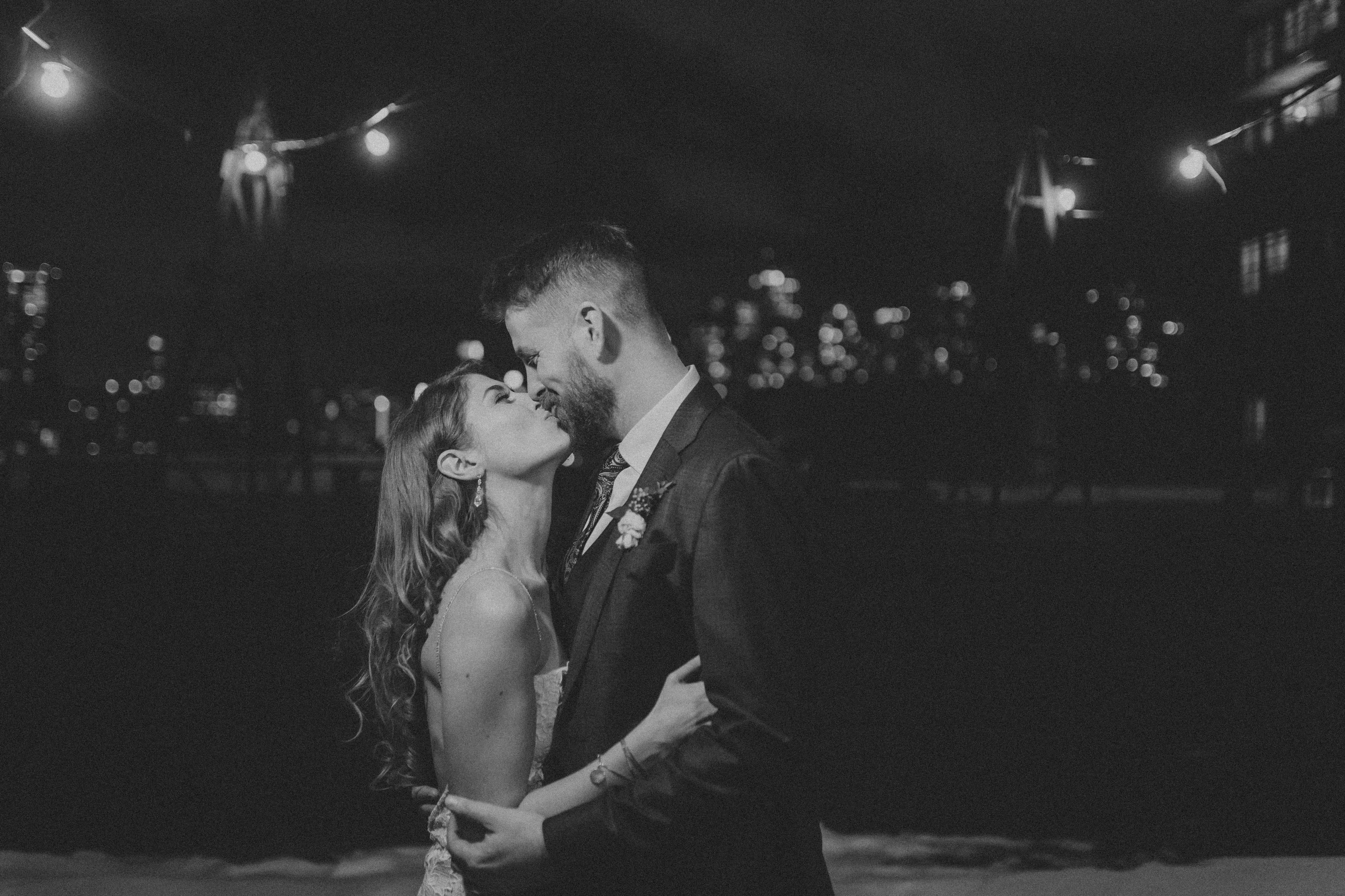 bride and groom kissing alone on the rooftop at the Burroughes Building at night