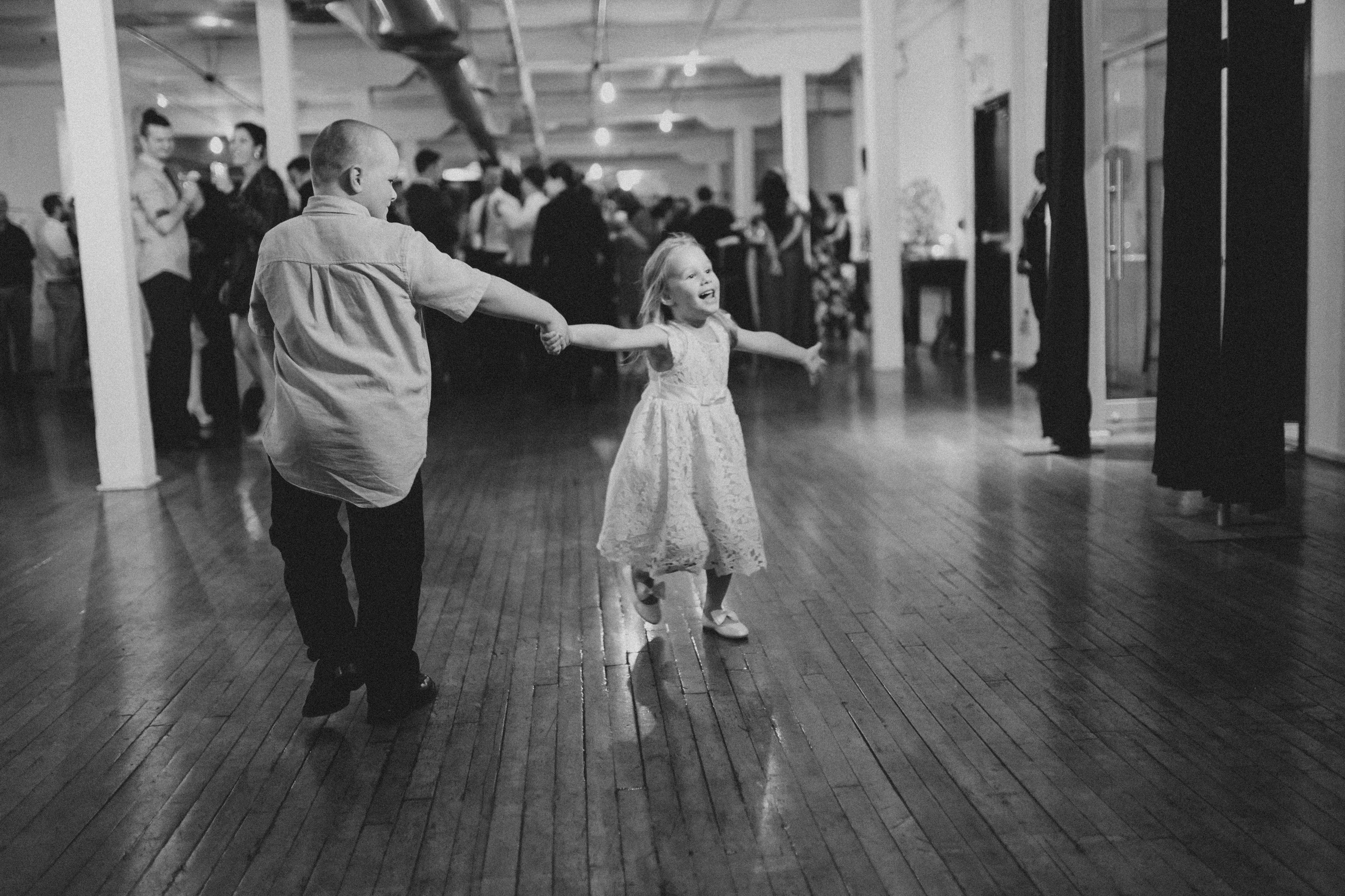 a young boy dancing with an even younger girl on the dancefloor