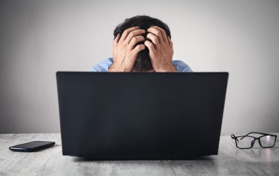 Caucasian stressed businessman sitting and covering face in office, ways to reduce the permanent stress.