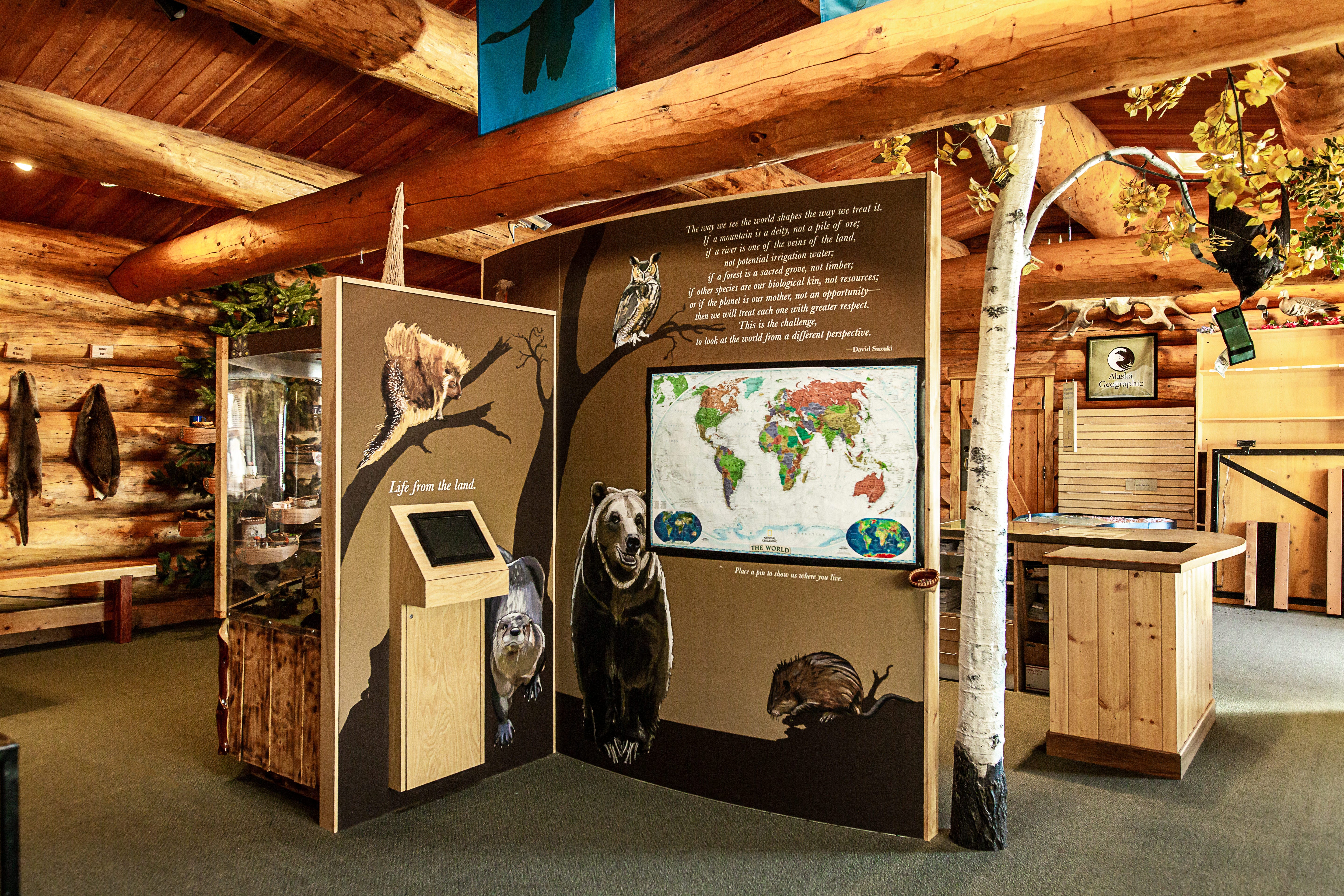 inside the Tetlin visitor center showing log cabin interior and interpretive panels