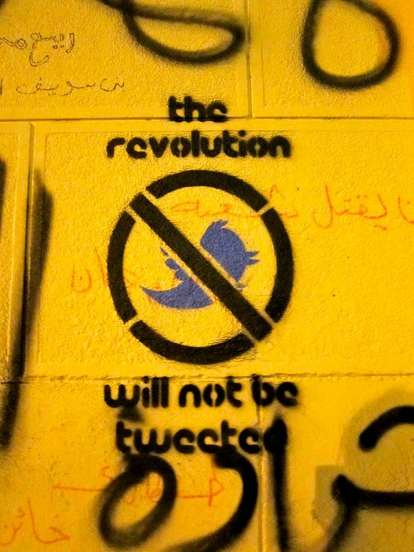 Street art saying “the revolution will not be tweeted” with a Twitter bird with a line through it