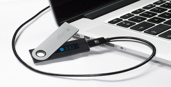 Ledger Nano S being connected to a laptop via USB cable