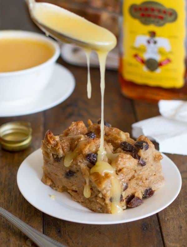 Rum sauce drips from spoon into bread pudding