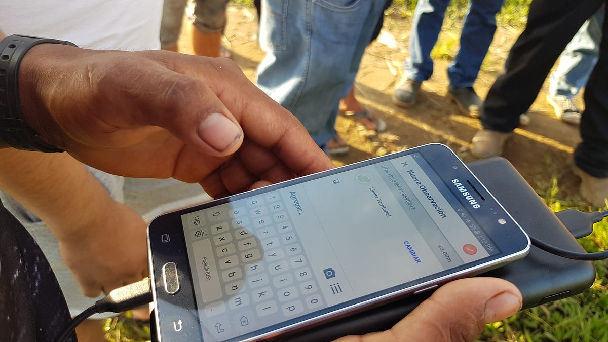 Photograph of an indigenous person using a phone to enter text